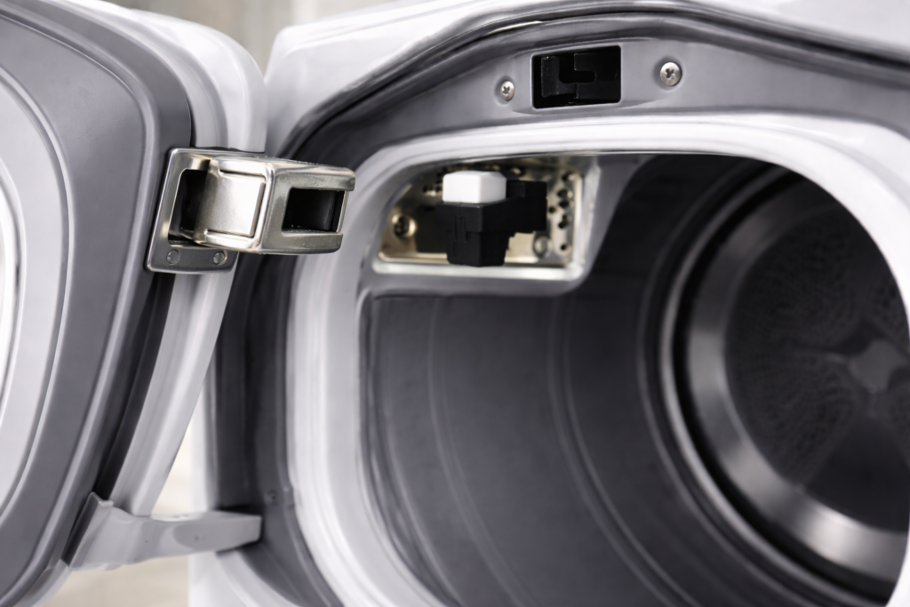 Dryer door latch pressing the door switch inside the dryer frame